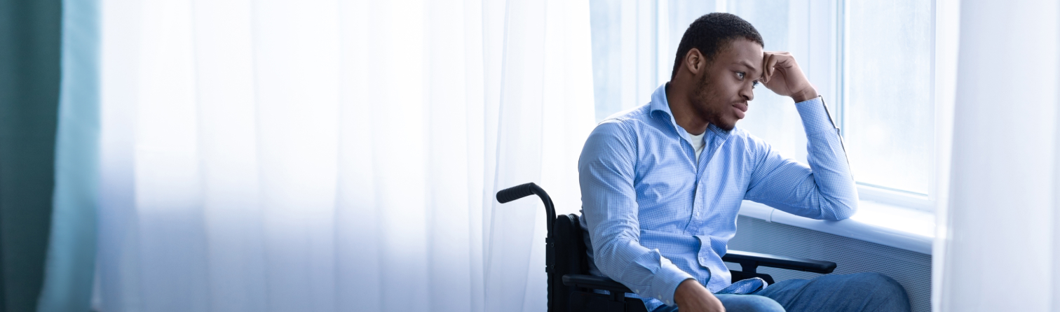 Paraplegic black man in wheelchair feeling depressed and lonely